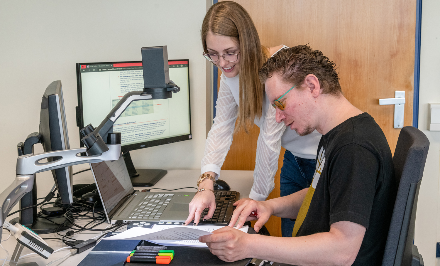 Foto Teilnehmer und Dozentin im Gespräch an einemPC-Arbeitsplatz