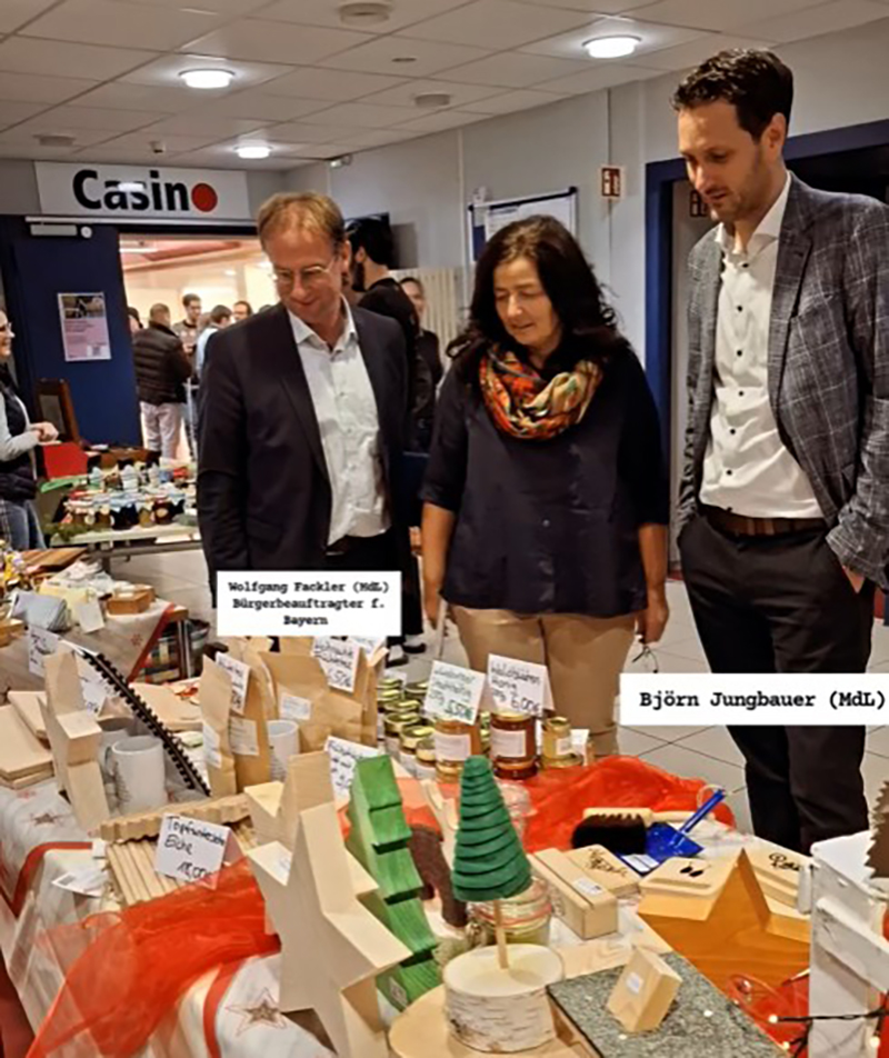Teamleiterin Christine Haupt-Kreutzer mit Björn Jungbauer und Wolfgang Fackler an einem Stand des Basars Teamleiterin Christine Haupt-Kreutzer mit Björn Jungbauer und Wolfgang Fackler an einem Stand des Basars